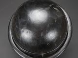 a close up of a metal object on a black surface