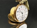 une montre de poche en or posée sur une table en verre