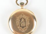 an antique gold pocket watch on a white background with a monogram