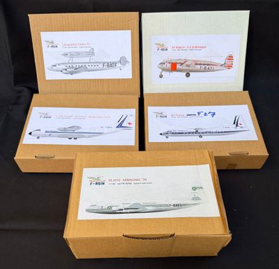 quatre boîtes contenant des maquettes d'avions, posées sur une surface noire