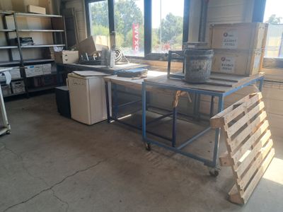 des cartons empilés sur une table dans une pièce dotée de nombreuses fenêtres
