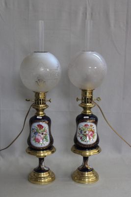 une paire de lampes anciennes ornées de fleurs peintes sur fond blanc