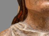 a wooden statue of a woman with a scarf around her neck