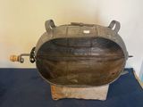 une grande casserole en métal posée sur un tapis bleu