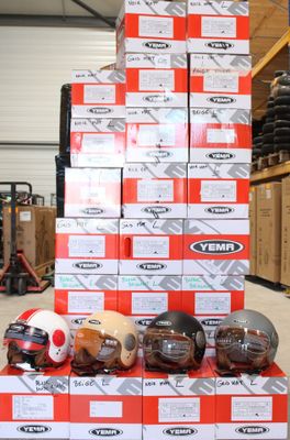 Des cartons de casques sont empilés les uns sur les autres dans un entrepôt