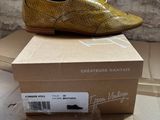 yellow snake skin shoes on top of a cardboard box on a table