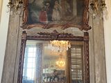 un miroir au milieu d'une pièce où est accroché un tableau au mur