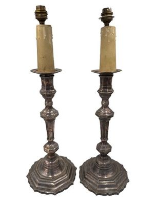 pair of antique silver candlesticks with candles on each side