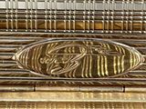 a close up of a gold plate with a bird on it