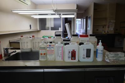 many bottles of liquid sitting on the counter in the kitchen