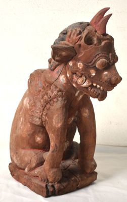 une image représentant une statue en bois d'un chien à la grosse tête