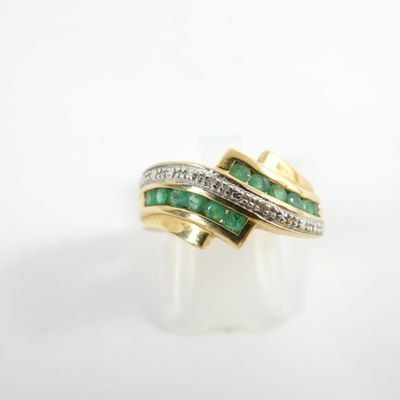 a close up of a gold ring with emeralds and diamonds