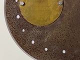 a metal plate with holes on it on a white surface