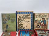 several books are lined up on a white surface with a white background