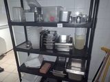 une étagère avec des casseroles et des poêles dans une cuisine