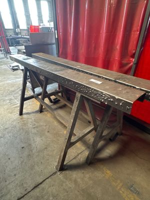 a long metal table with a red curtain in the background