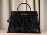 a black crocodile skin handbag on a wooden table