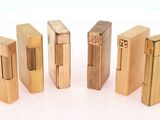 quatre briquets en bois sont alignés sur une surface blanche
