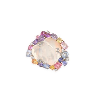 un gros plan d'une bague ornée d'une pierre blanche entourée de pierres multicolores