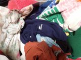 a pile of clothes sitting on top of a bed
