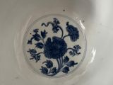 a blue and white plate with a flower design on it