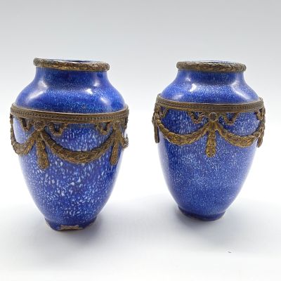 deux vases bleus posés l'un à côté de l'autre sur une surface blanche