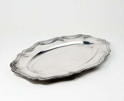 une assiette en argent posée sur une surface blanche, avec une cuillère dessus