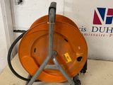 un casque de chantier orange posé sur le sol, à côté d'un panneau