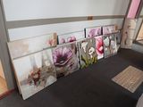Il y a de nombreuses photos de fleurs accrochées au mur dans cette pièce