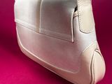 beige leather handbag on a pink background with copy space