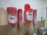 trois extincteurs accrochés au mur dans une pièce