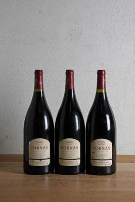 three bottles of wine are lined up on a wooden table