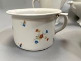 a cup and saucer sitting on a table next to a plate