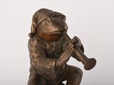 bronze figurine of a monkey playing a trumpet