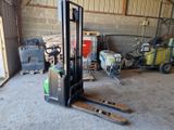 un chariot élévateur dans un garage où se trouvent de nombreux outils
