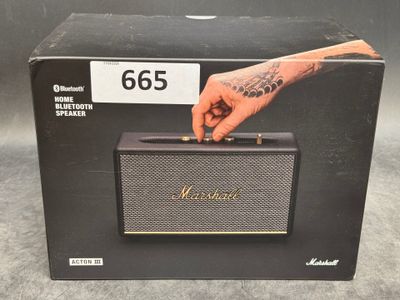 Sur la boîte de l'enceinte Bluetooth Marshall, on voit une main qui la tient.