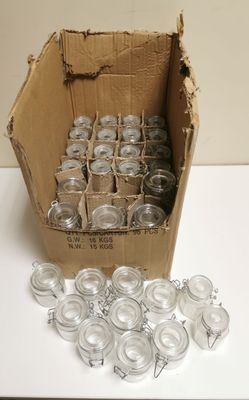 a cardboard box filled with empty glass jars on a table