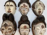plusieurs masques africains accrochés au mur d'une pièce