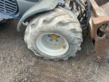 a tractor that is sitting on the ground next to a pile of dirt
