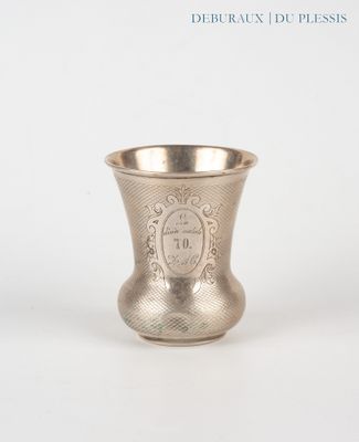 a silver cup that is sitting on a white surface