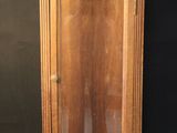 an old wooden clock with a glass case on a black background