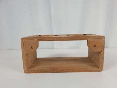 une petite boîte en bois percée de deux trous