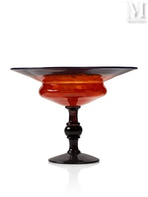 un bol en verre orange et noir posé sur un socle noir
