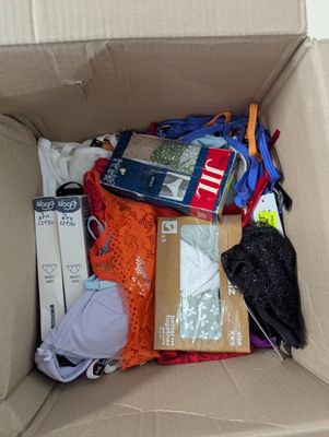 a cardboard box filled with clothing and a cell phone