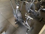 a stationary exercise bike with a fan in the middle of the room