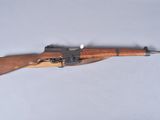 an old rifle with a wooden barrel on a white surface