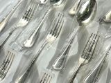 many forks and spoons in a plastic bag