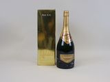 a close up of a bottle of champagne next to a gold box
