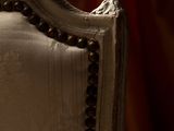 close up of the back of a chair with a red curtain in the background