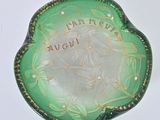 a green and gold plate with a picture of a woman on it